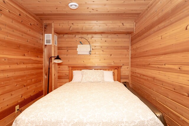 bedroom featuring visible vents, wood ceiling, and wooden walls