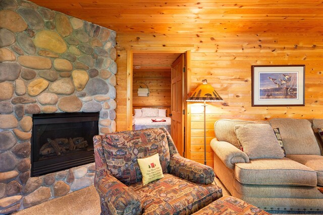 carpeted living room with wooden ceiling, a fireplace, and wood walls