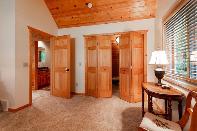 interior space with light carpet, wooden ceiling, baseboards, and lofted ceiling