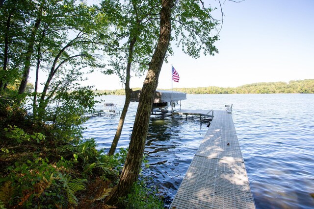 dock area featuring boat lift and a water view