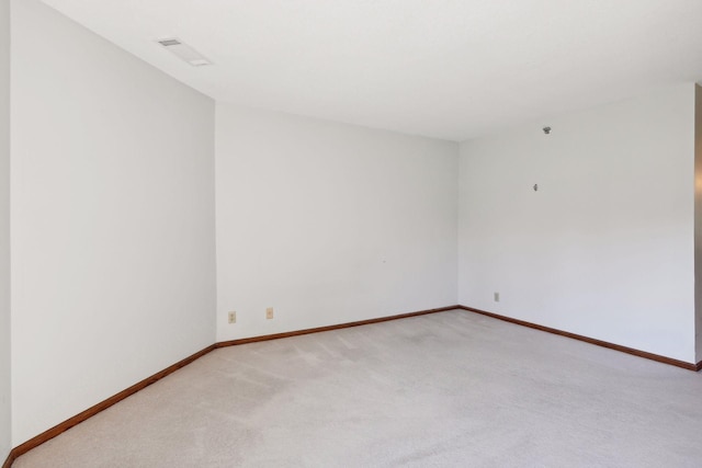 unfurnished room featuring light carpet