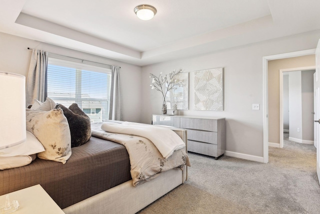 bedroom with a tray ceiling and light carpet