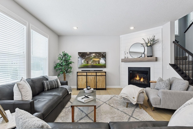 living room featuring a fireplace, light hardwood / wood-style floors, and a textured ceiling