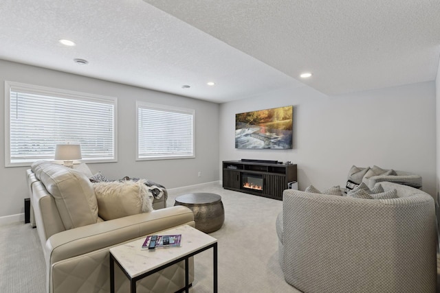 carpeted living room featuring a textured ceiling and a wealth of natural light