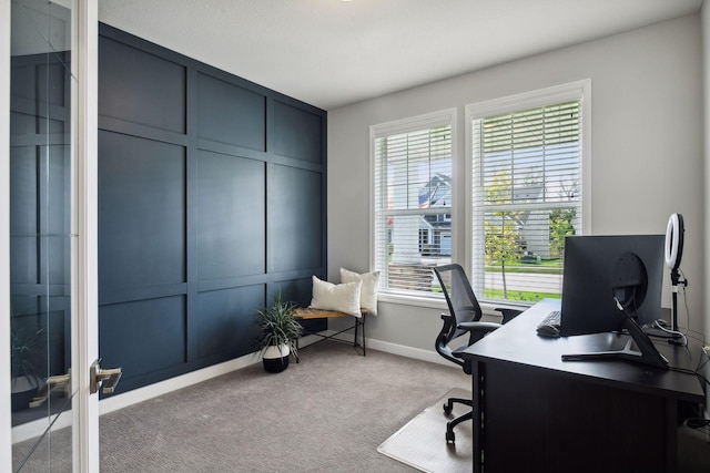 carpeted office featuring a decorative wall and baseboards