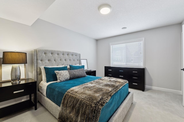 bedroom with light colored carpet and baseboards