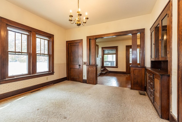 interior space with carpet floors and an inviting chandelier