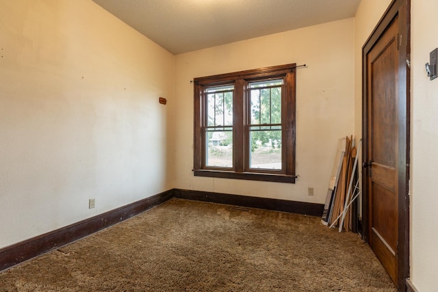 carpeted empty room with a textured ceiling