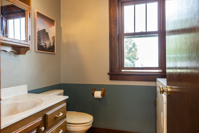 bathroom with vanity, toilet, and a healthy amount of sunlight