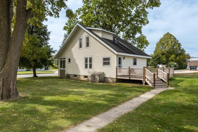 rear view of house featuring a deck and a lawn