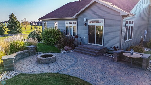 rear view of house with an outdoor fire pit and a patio area