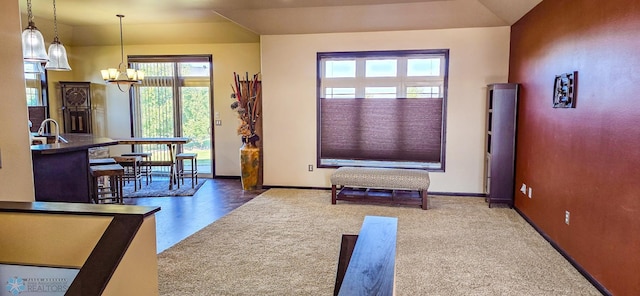 carpeted living room featuring vaulted ceiling, sink, and a chandelier