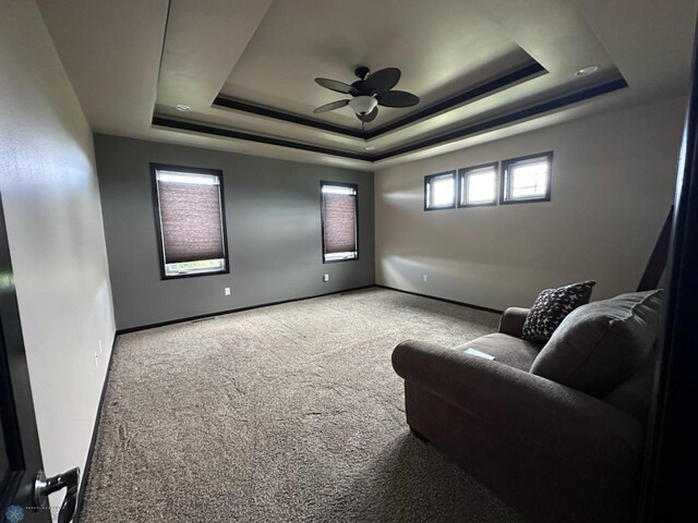 interior space featuring ceiling fan and a raised ceiling