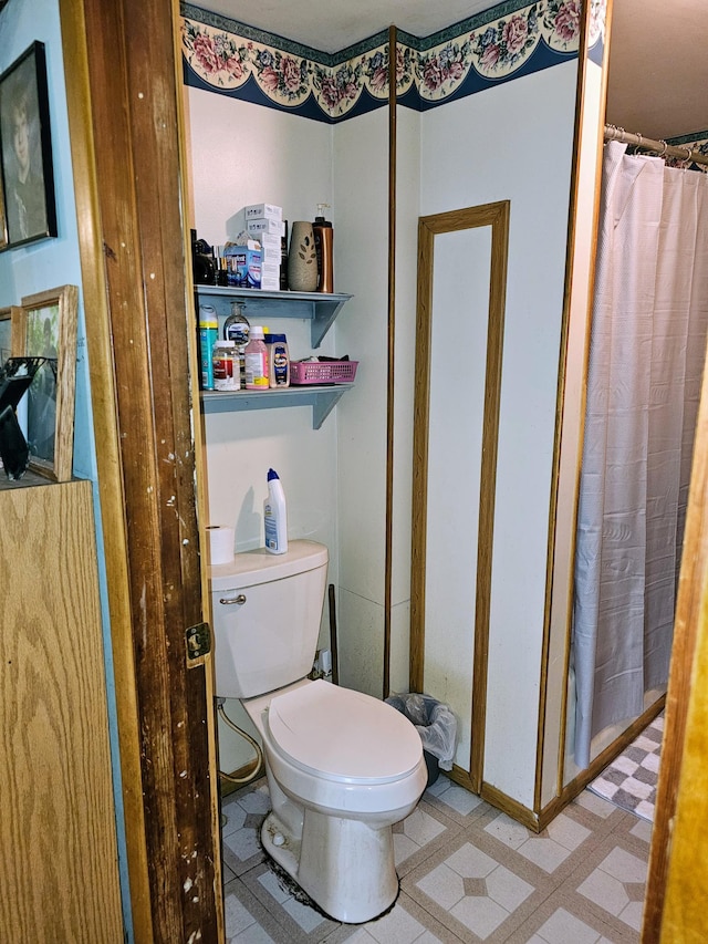 bathroom with a shower with curtain and toilet