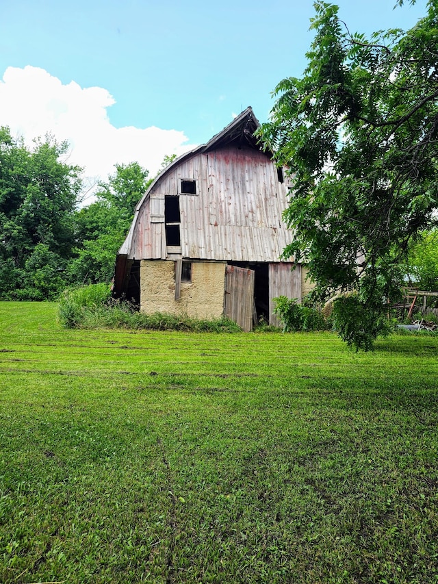 view of home's exterior featuring a lawn and an outbuilding