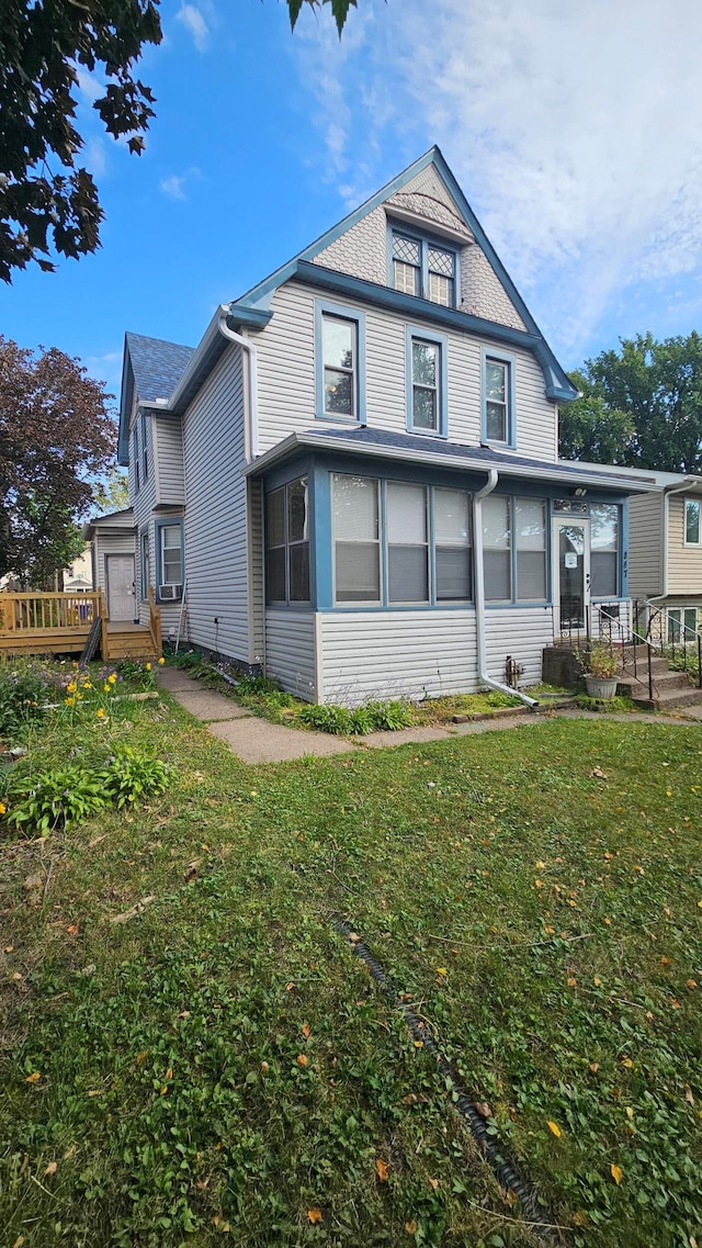 back of property featuring a yard and a deck