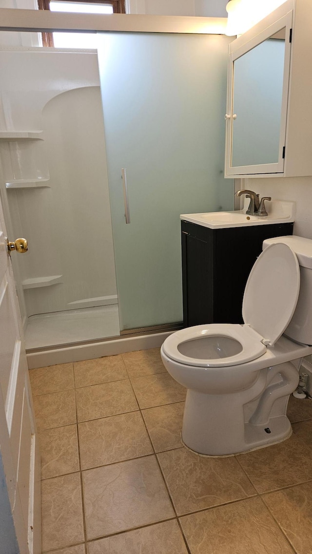 bathroom featuring vanity, tile patterned flooring, toilet, and an enclosed shower