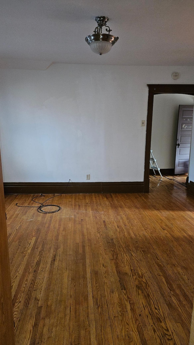 unfurnished room featuring a textured ceiling and dark hardwood / wood-style floors