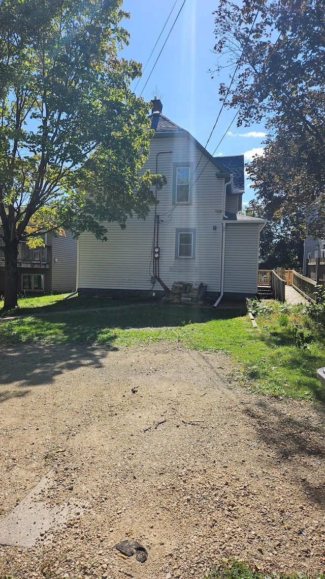 view of side of property with a yard and a wooden deck