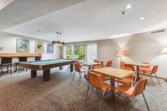 game room featuring dark carpet, a textured ceiling, wood walls, and pool table