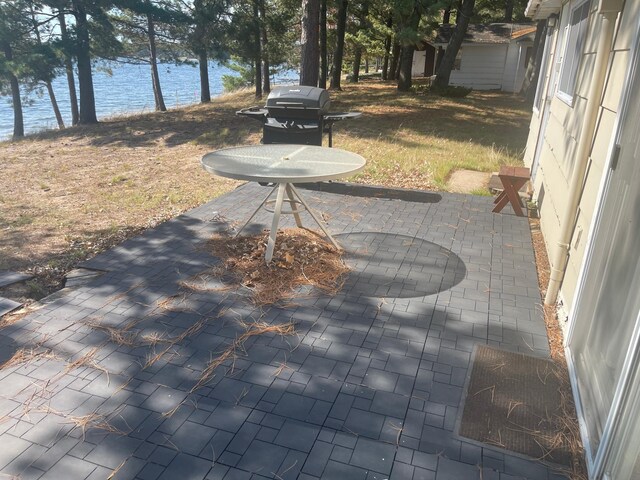 view of patio with a water view and area for grilling