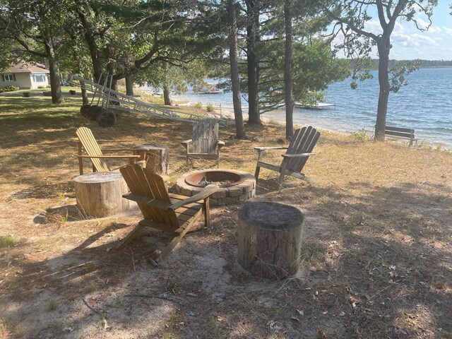 view of yard with a water view and a fire pit