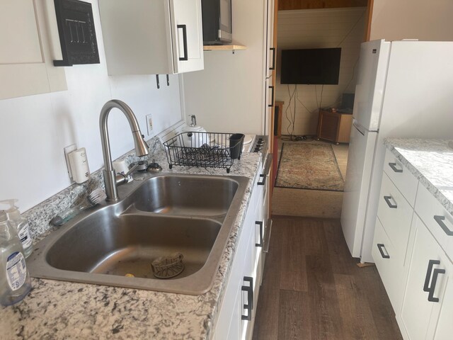 kitchen featuring sink, white cabinetry, white fridge, decorative backsplash, and dark hardwood / wood-style flooring