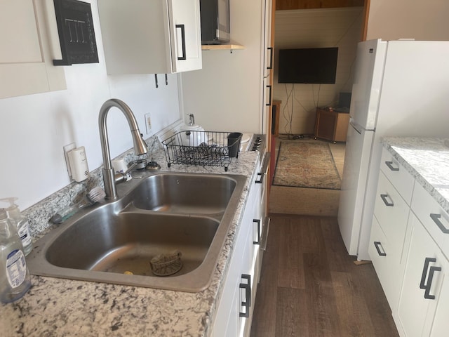 24126 County Road 19, Merrifield, MN 56465 - kitchen with freestanding refrigerator, dark wood-style flooring, a sink, and white cabinets