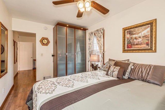 bedroom featuring ceiling fan and dark wood-type flooring