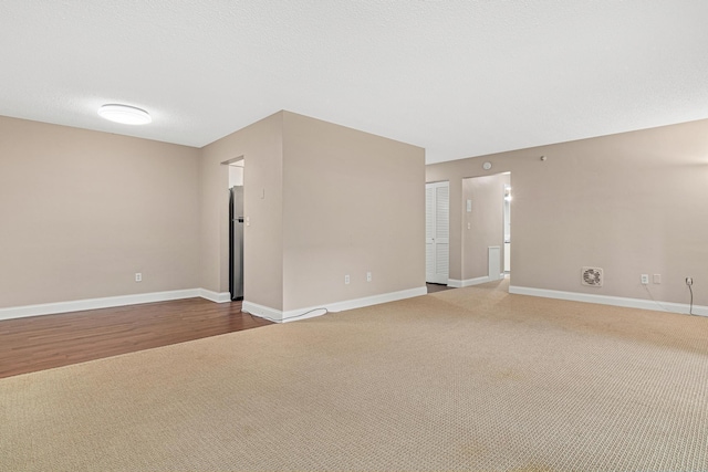 unfurnished room featuring a textured ceiling and hardwood / wood-style floors