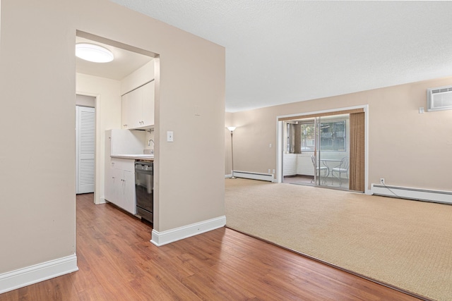 hall with a wall unit AC, baseboard heating, sink, and wood-type flooring