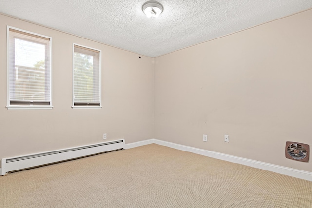 carpeted spare room with a baseboard heating unit and a textured ceiling