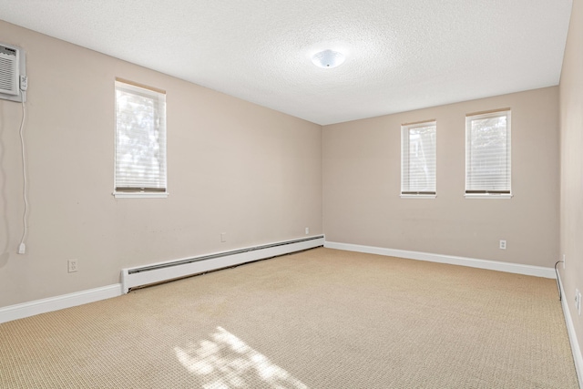 carpeted spare room featuring a wealth of natural light, a baseboard radiator, a wall mounted air conditioner, and a textured ceiling