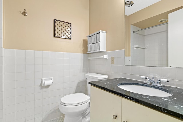 bathroom featuring tile walls, vanity, a shower, and toilet