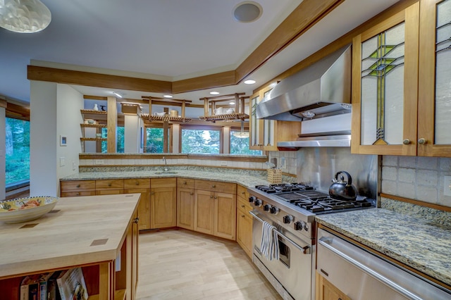 kitchen featuring high end stainless steel range oven, wall chimney range hood, light hardwood / wood-style flooring, backsplash, and wooden counters