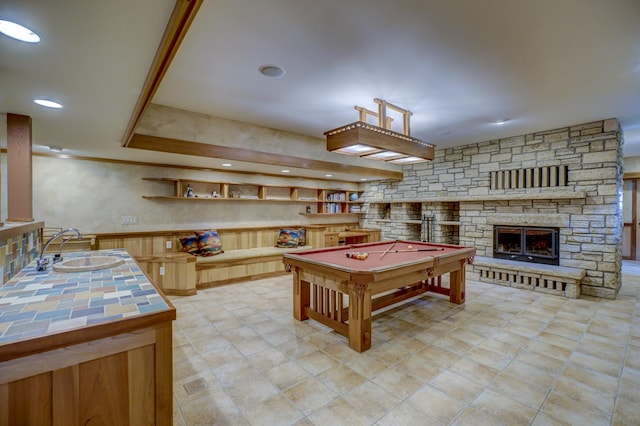 rec room with pool table, a stone fireplace, and sink