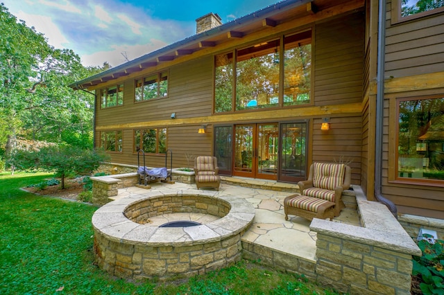 back of property with a patio area and an outdoor fire pit