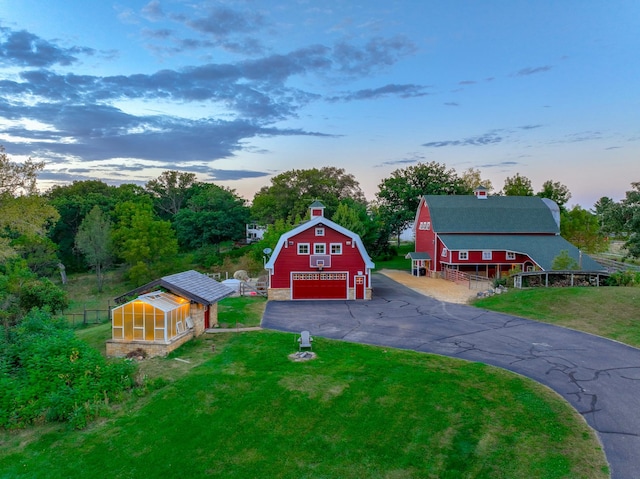 view of front of property featuring a garage, a yard, and an outbuilding