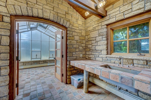 interior space featuring lofted ceiling with beams and sink