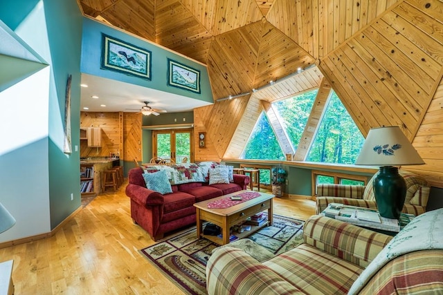 living room featuring light hardwood / wood-style flooring, wooden walls, and ceiling fan