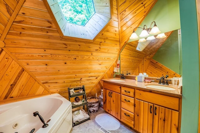 bathroom with vaulted ceiling with skylight, wood walls, vanity, and a bathing tub