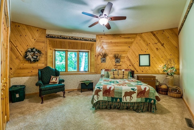 bedroom featuring ceiling fan, vaulted ceiling, wooden walls, and carpet flooring