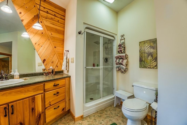 bathroom featuring vanity, wood walls, toilet, and a shower with door