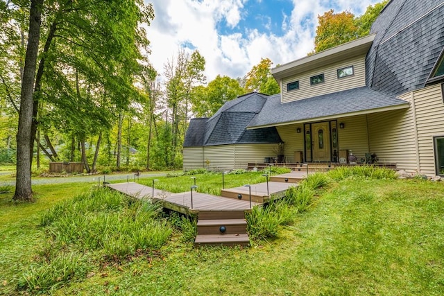 back of house featuring a lawn and a wooden deck