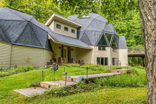 back of house featuring a lawn and a deck