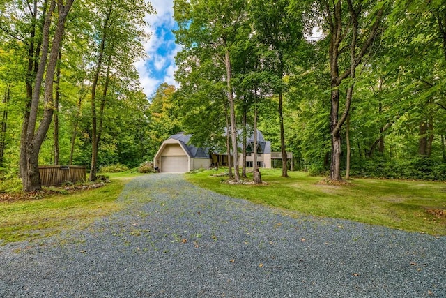 view of front of home with a garage, a front lawn, and an outbuilding