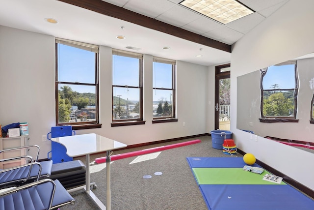 recreation room with carpet and beamed ceiling