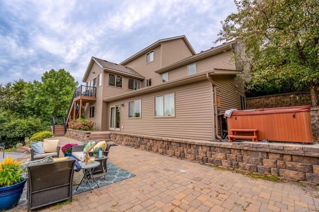 exterior space featuring a patio, outdoor lounge area, and a hot tub