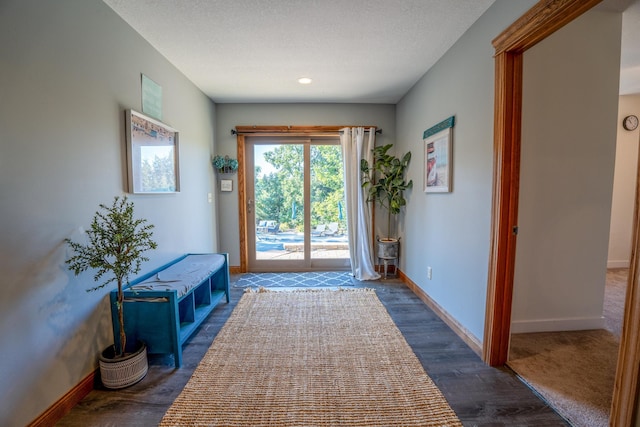 entryway with a textured ceiling and dark hardwood / wood-style flooring