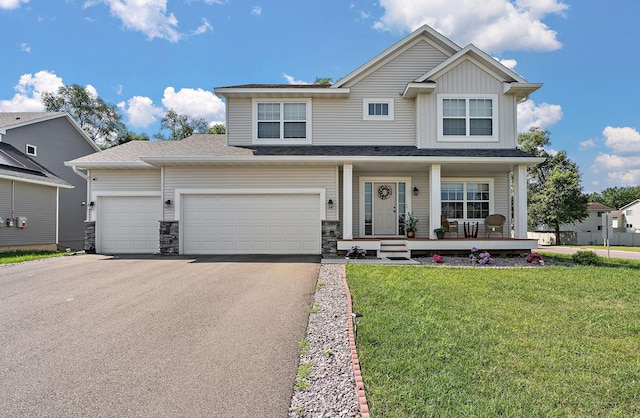 view of front facade featuring covered porch, a front yard, and a garage